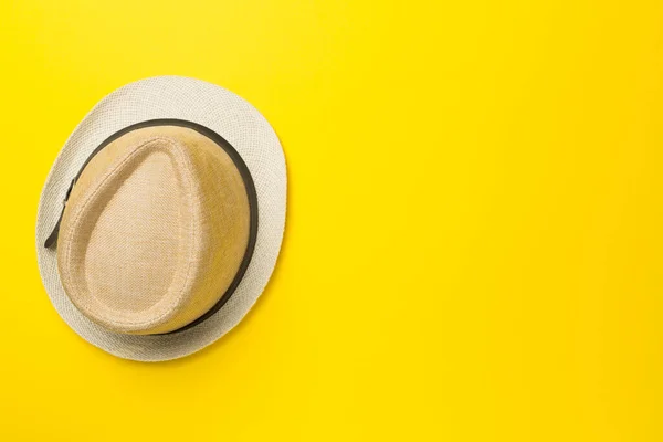 Straw hat on color background, top view.
