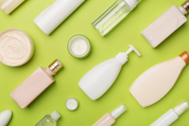 Renkli arka planda farklı kozmetik şişeleri ve konteynır, üst görünüm.