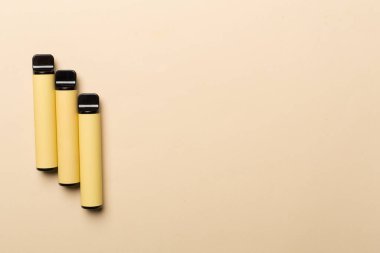 Disposable electronic cigarettes on color background, top view