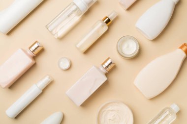 Renkli arka planda farklı kozmetik şişeleri ve konteynır, üst görünüm.