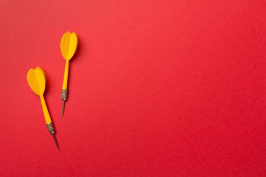 Yellow darts on color background, top view.
