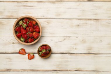 Ahşap arka planda taze çilek kasesi, üst manzara..