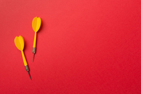 Yellow darts on color background, top view.
