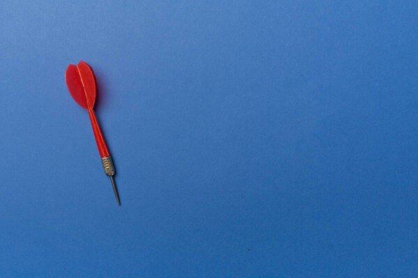 Красный дартс на цветном фоне, вид сверху.