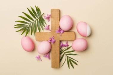 Çapraz ve arka planda palmiye yaprakları olan pembe Paskalya yumurtaları.