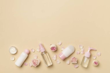 Set of small cosmetic bottles on color background, top view.