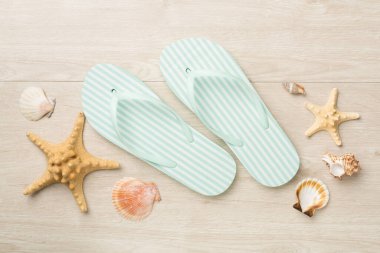 Ahşap arka planda çizgili parmak arası terlikler, üst görünüm