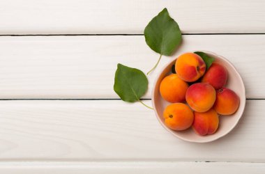 Composition with ripe apricots on wooden background, top view.