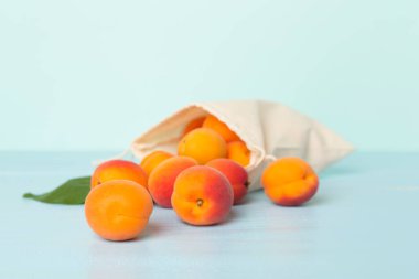 Composition with ripe apricots on wooden table.