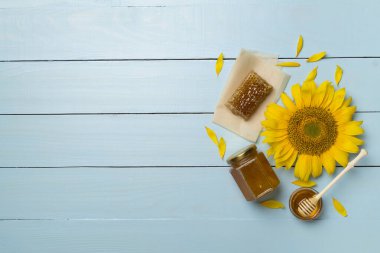 Flat lay with sunflower honey on wooden background, top view.