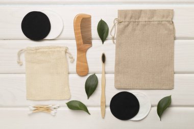 Flat lay with natural biodegradable accessories on wooden background, top view.