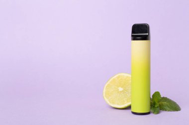 Disposable electronic cigarette and fruit on color background