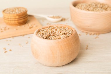 Bowls with wholegrain spelt farro on wooden table.