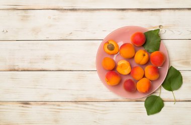 Composition with ripe apricots on wooden background, top view.