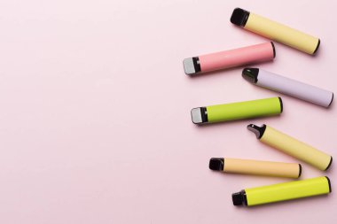 Disposable electronic cigarettes on color background, top view
