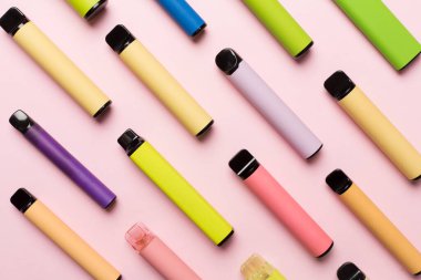 Disposable electronic cigarettes on color background, top view