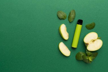 Disposable electronic cigarettes with fruits on color background, top view