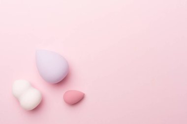 Beauty blenders on color background, top view