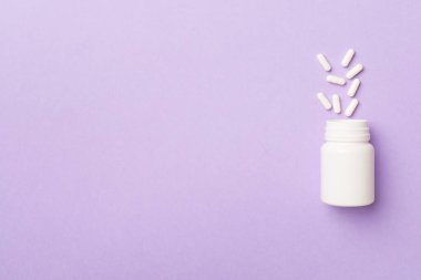 Arka planda haplar olan beyaz şişe..