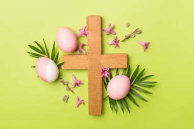 Çapraz ve arka planda palmiye yaprakları olan pembe Paskalya yumurtaları.