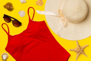 Renkli arka planda güzel kırmızı bikini ve aksesuarlar, üst görünüm.