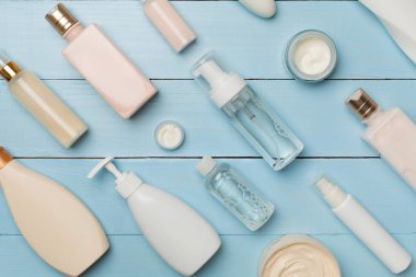 Ahşap arka planda farklı kozmetik şişeler ve konteynırlar..