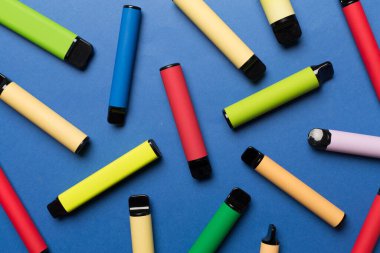 Disposable electronic cigarettes on color background, top view