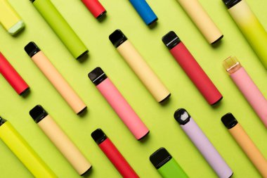 Disposable electronic cigarettes on color background, top view