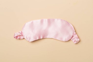 Renk arkaplanında uyuyan göz maskesi, üst görünüm.