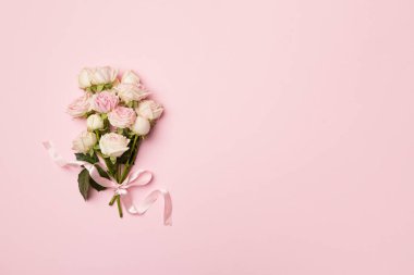 Small bouquet with rose flowers on color background, top view.