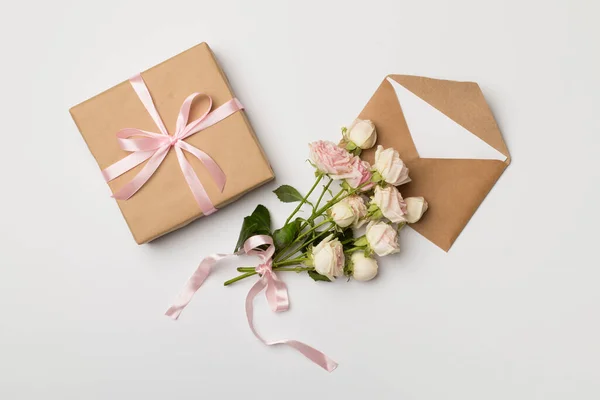 Envelop Geschenkdoos Rozenbloemen Witte Achtergrond Bovenaanzicht — Stockfoto