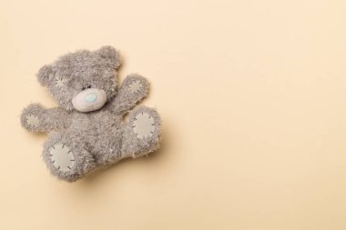 Cute teddy bear on color background, top view