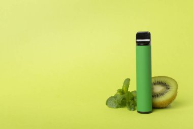 Disposable electronic cigarette and fruit on color background