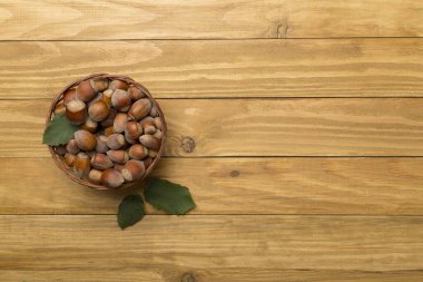 Ahşap arka planda yeşil yapraklı fındıklar..