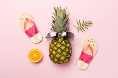 Güneş gözlüklü yaratıcı ananas hipster renkli arka plan, üst görünüm