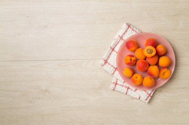 Composition with ripe apricots on wooden background, top view.