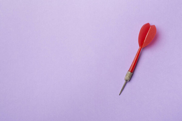 Красный дартс на цветном фоне, вид сверху.