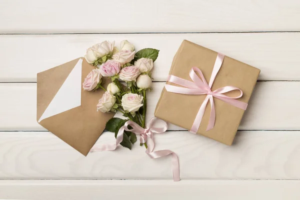 Envelop Geschenkdoos Rozenbloemen Houten Ondergrond Bovenaanzicht — Stockfoto