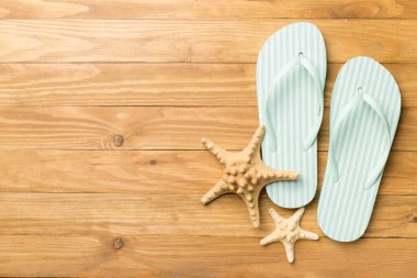 Ahşap arka planda çizgili parmak arası terlikler, üst görünüm