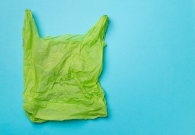 Disposable plastic bag on color background, top view.