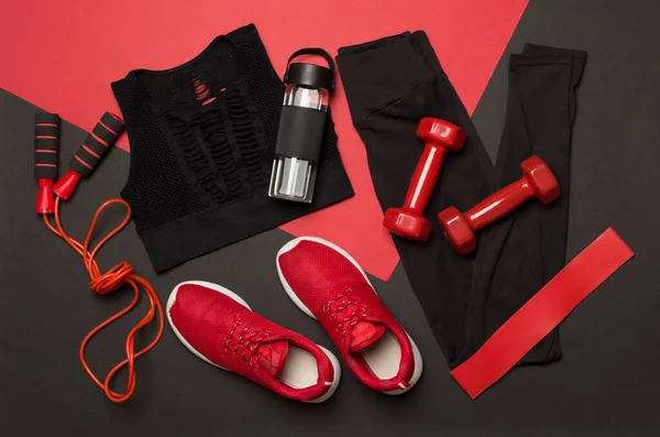 Black gym outfit on color background, top view
