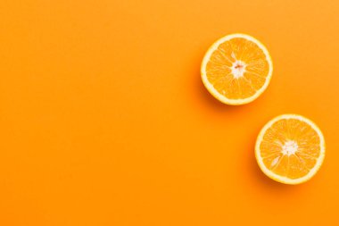 Flat lay with fresh oranges and leaves on color background.