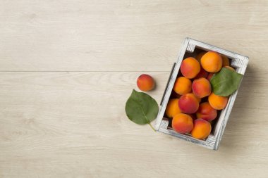 Composition with ripe apricots on wooden background, top view.