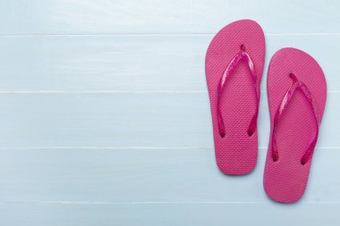 Tahta arka planda parlak parmak arası terlikler, üst görünüm