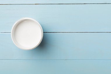 Ahşap zemin üzerinde boya kovası aç, üst görünüm.