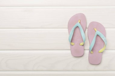 Tahta arka planda parlak parmak arası terlikler, üst görünüm