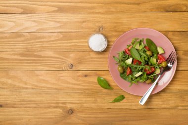 Tahta arka planda roka, ıspanak ve sebzeli taze salata..