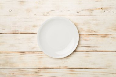 Tahta arka planda boş yuvarlak tabak, üst görünüm,