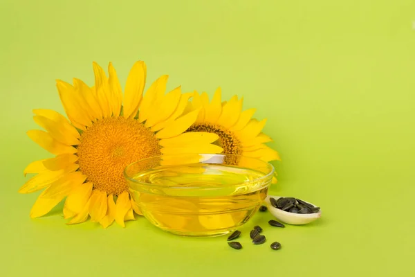 Sunflower oil, seeds and flower on color background.