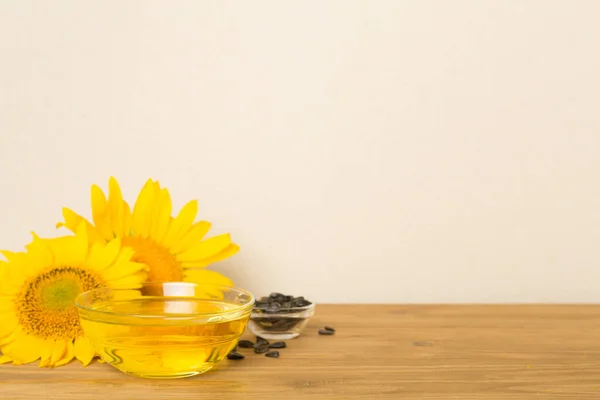 stock image Sunflower oil, seeds and flower on wooden table.